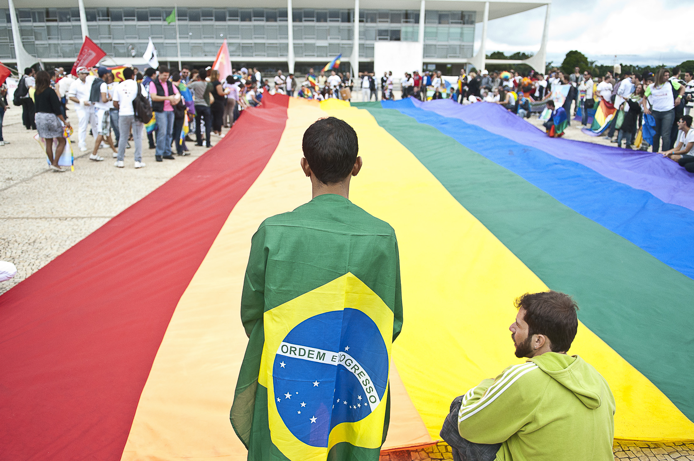 Un hombre con una bandera de Brasil y bandera LGTB
