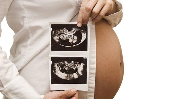 La Barriga de una embarazada enseñando unas ecografías