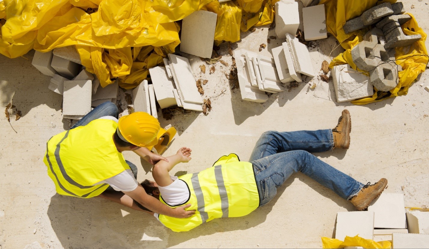 Un obrero de la construcción caído y otro ayudándole