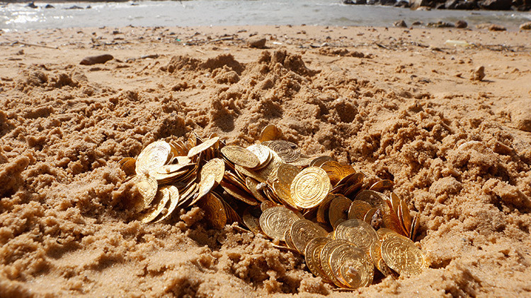 Monedas en la arena de una playa