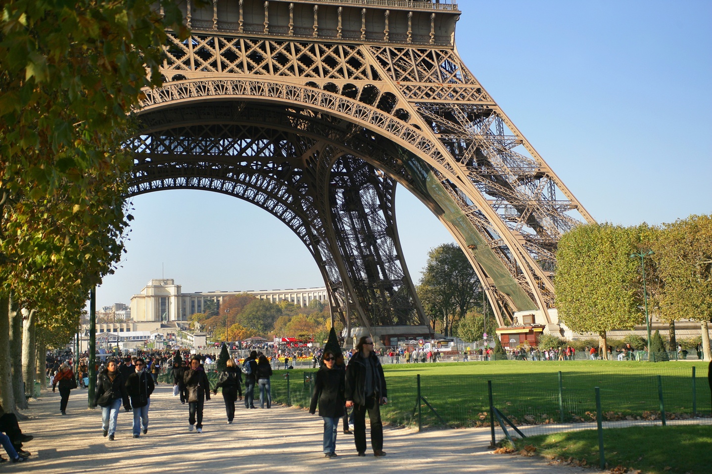 Personas paseando bajo la Torre Eiffel