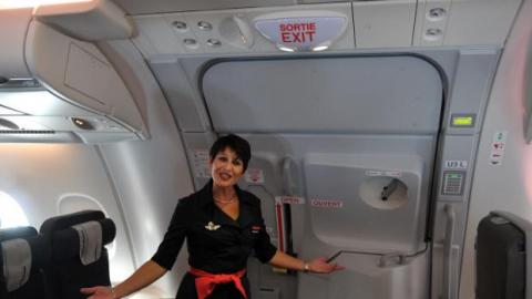 Una azafata en la puerta de un avión