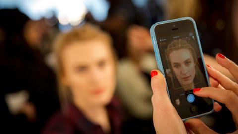 Fotografiando a una persona con el teléfono móvil