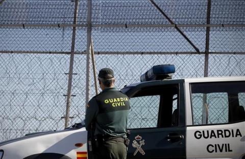 Un guardia civil de espalda en la valla de Melilla