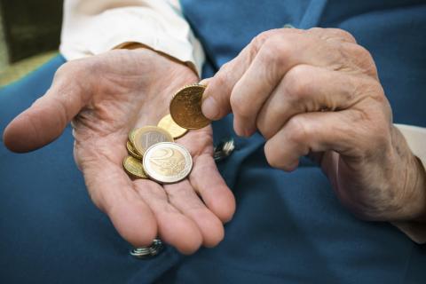 Monedas en la mano de un anciano