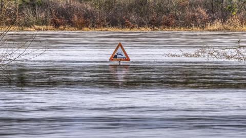 Señal de tráfico en medio de un río inundado