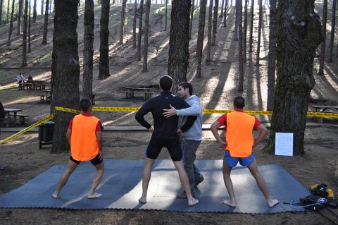 Fisioterapeuta con tres hombres haciendo ejercicios