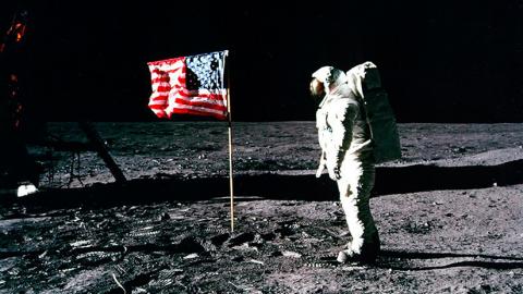 Astronauta en la Luna con bandera de EEUU
