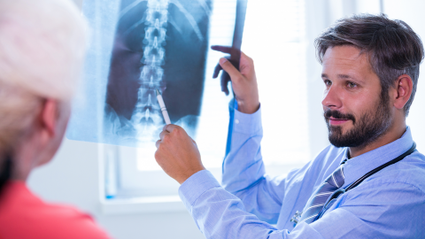 Médico con paciente enseñando radiografía