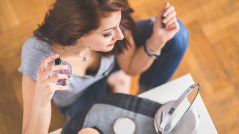 Una mujer poniéndose perfume