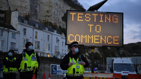Policías junto a un letrero que insta a la población a vacunarse contra el covid-19 en Kent, Reino Unido, 23 de diciembre de 2020
