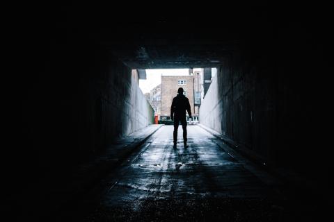 Hombre en callejón oscuro